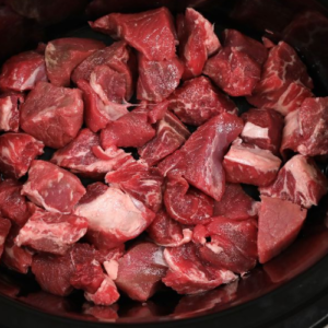 Put chopped beef into a slow cooker and cover with flour for this amazing dish